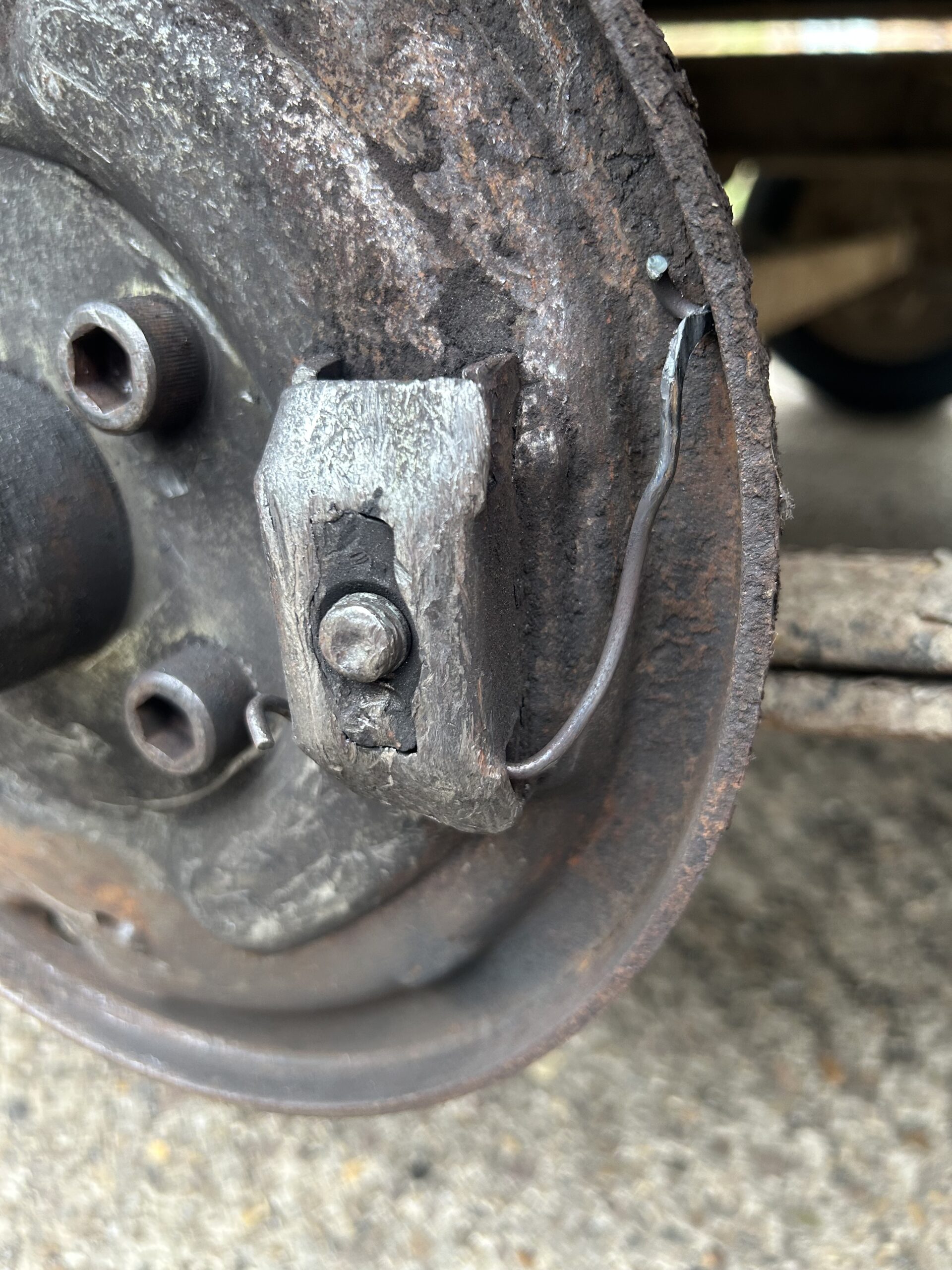 Close-up of the damaged brake backplate on an Ifor Williams tipper trailer